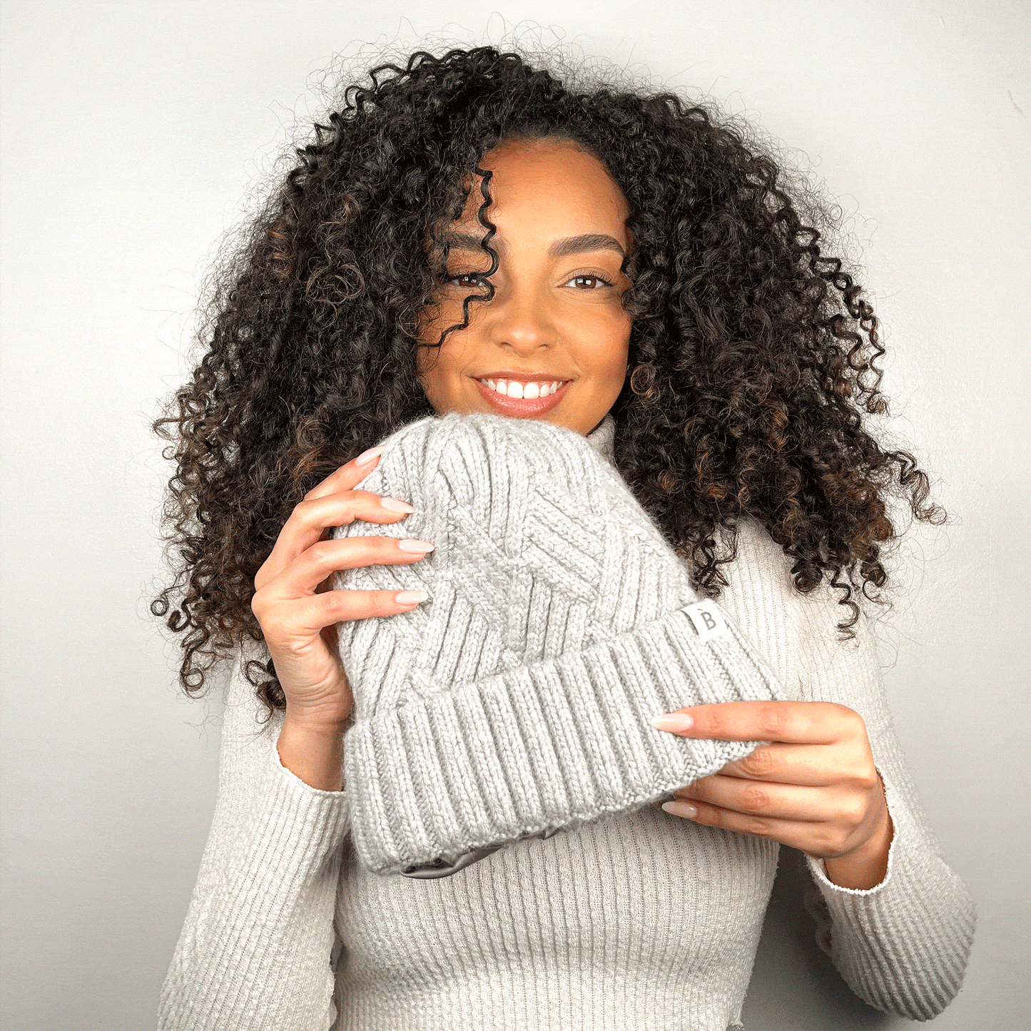 Curly hair model wearing silk lined beanie