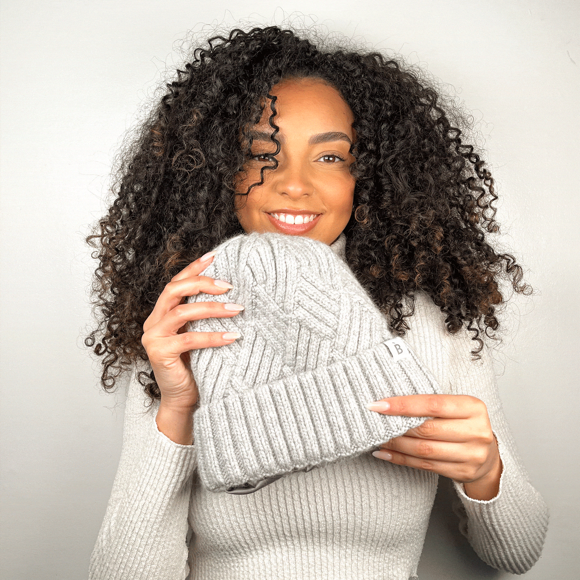 Curly hair model wearing silk lined beanie