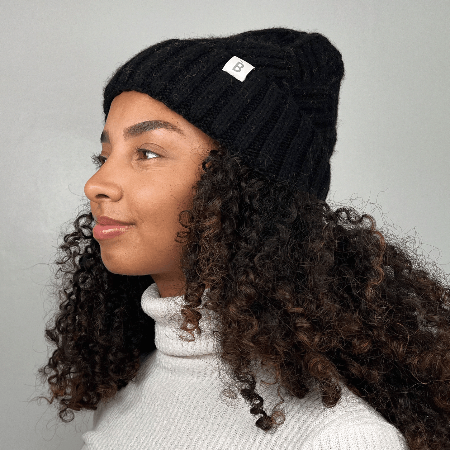 black silk lined beanie on curly hair model