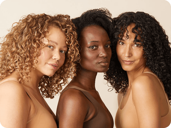 three women with curly hair facing the camera