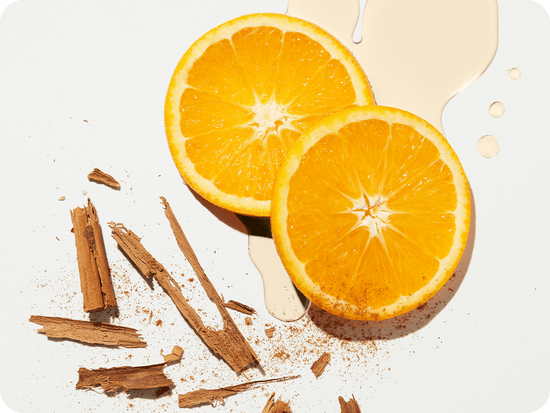 a flat-lay of two slices of orange and pieces of cinammon stick