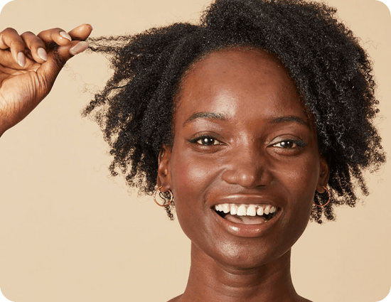 close-up of a smiling woman with black, coily hair