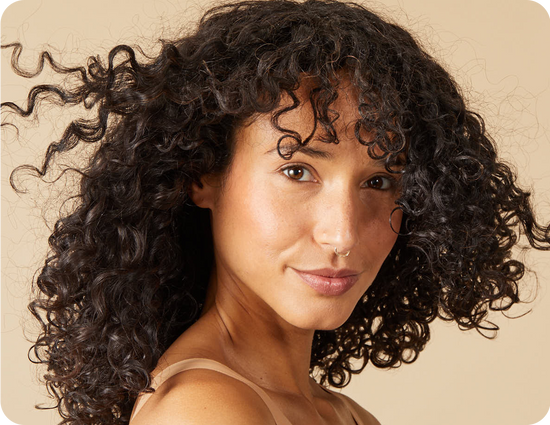 close up of a woman with curly, dark-brown hair