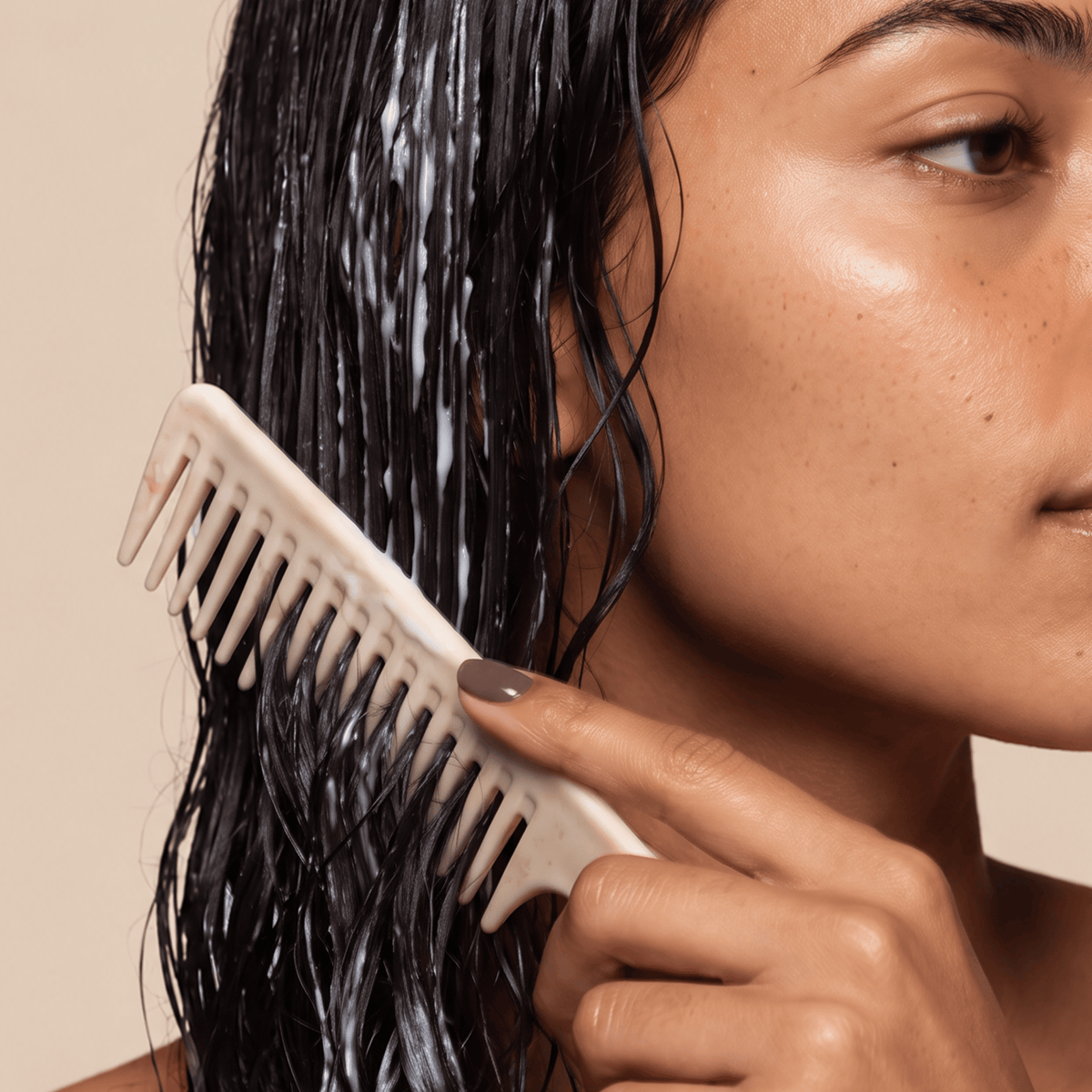 curly hair person applying Strength and Repair Duo to hair